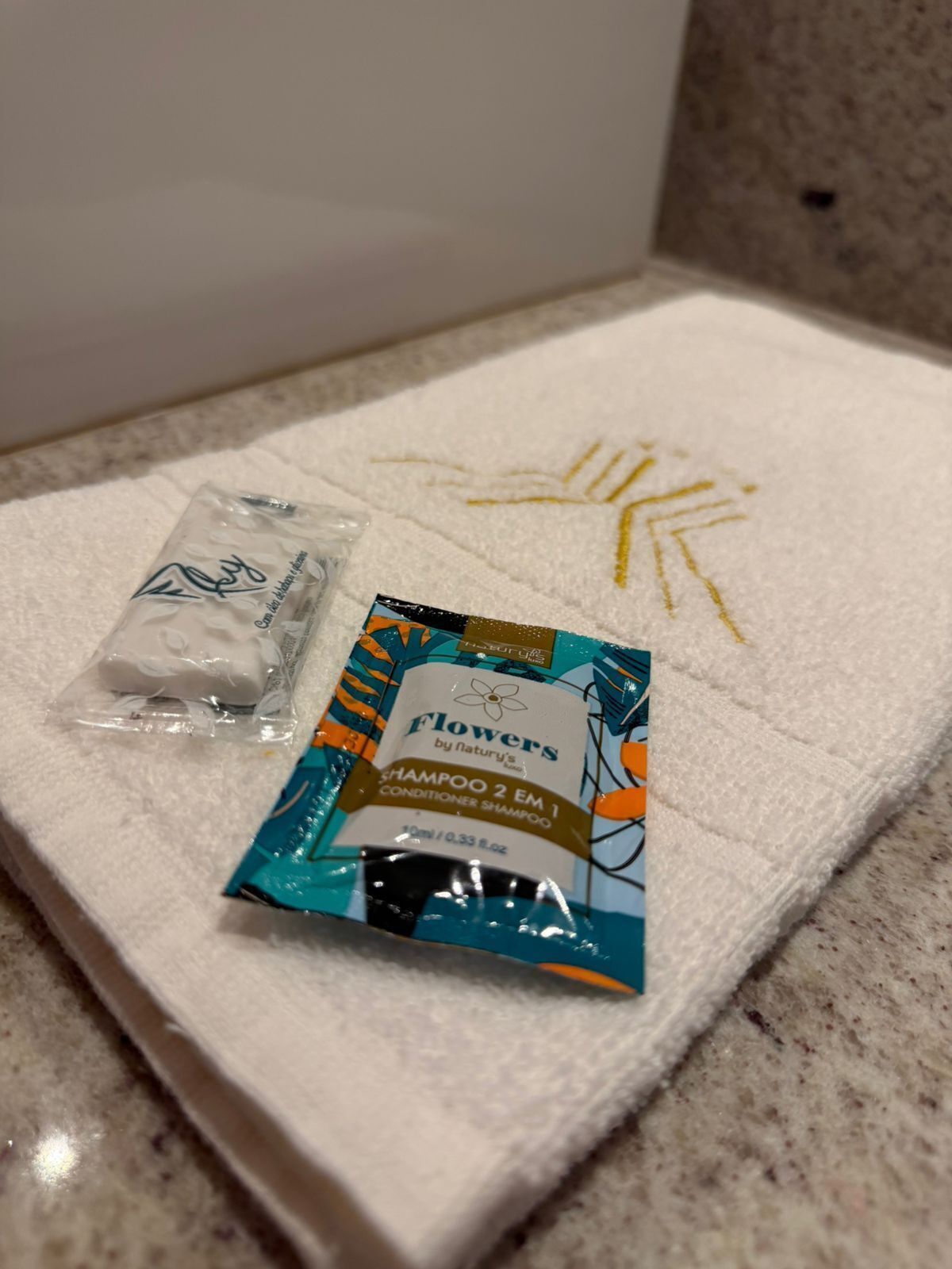 Un baño con una toalla blanca y dos botellas de champú.