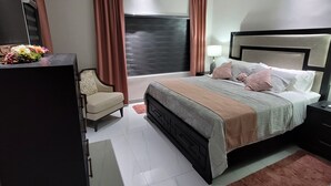 A modern bedroom with a bed, a desk, a chair, and a ceiling fan. - The Noble Retreat, your slice of paradise on Jamaica’s breathtaking North Coast. (Llandovery, St. Ann)