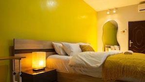 A bedroom with a bed, bedside table, lamp, and a mirror. - Cozy 2BED w/ Private Cinema @ Bodija, Ibadan (Ibadan)