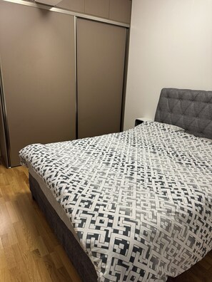 Ein Schlafzimmer mit einem Bett, einem Kleiderschrank und einem Nachttisch.