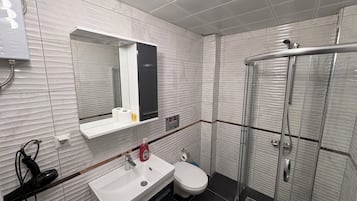 Klassieke studio | Badkamer | Een douche, een haardroger, pantoffels, handdoeken