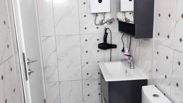 A bathroom with a toilet, sink, and shower.