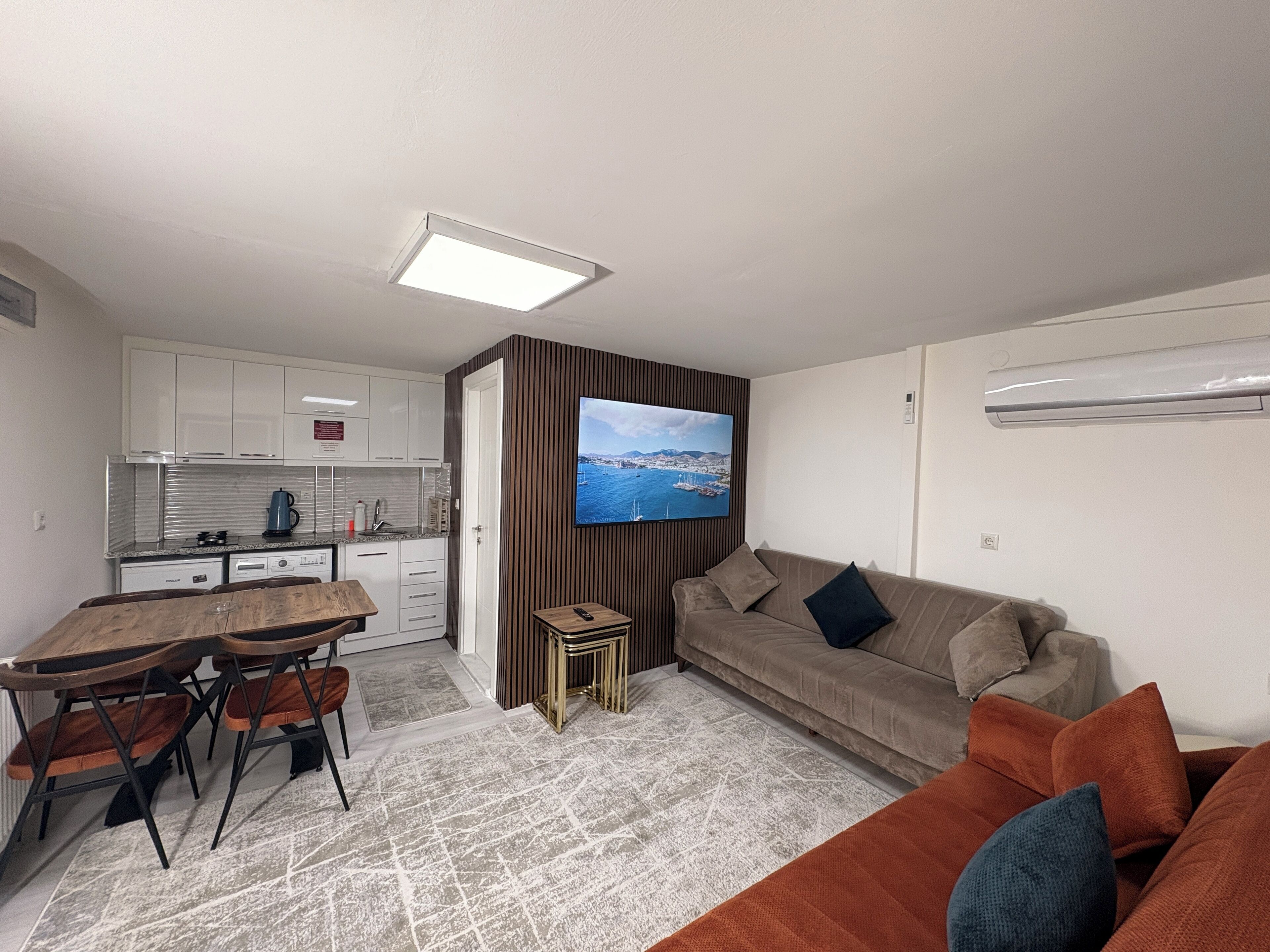 A modern living space with a kitchen, dining area, and a sofa.