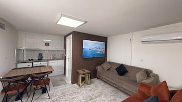 A modern living space with a kitchen, dining area, and a sofa.