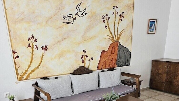 A living room with a sofa, coffee table, and two side tables. - Leta Santorini (Santorini)