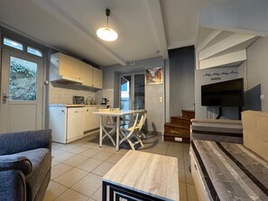 A compact living space with a kitchenette, a dining area, a sofa, and a TV. - Peaceful stay in Trouville, close to the beach (Trouville-sur-Mer)