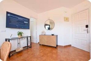 Habitació amb escriptori, cadira i televisió penjada a la paret que mostra els termes i condicions.