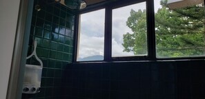 Une cuisine avec une fenêtre, des carreaux verts et un appareil électroménager blanc.