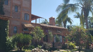 A large brick building with multiple windows and a tiled roof.