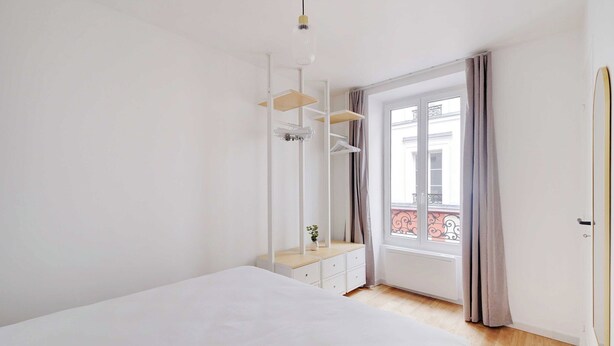 A bedroom with a bed, a dresser, a mirror, and a window with curtains. - Charming Apartment 1br/3p - Oberkampf (Paris)