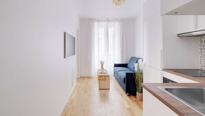 A modern kitchen with a wooden countertop, a built-in sink, and a window with sheer curtains. - Charming Apartment 1br/3p - Oberkampf (Paris)