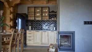 Een moderne keuken met houten kastjes, een backsplash van visgraatmozaïek tegels, en een inbouwfornuis.