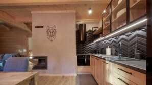 A modern kitchen with a herringbone tile backsplash, wooden cabinets, and a stainless steel range hood.