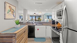 Een moderne keuken met dakraam, roestvrijstalen apparatuur en uitzicht op de omgeving.