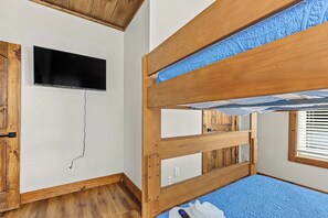 A bunk bed with a television mounted on the wall above it. - Amazing 5BD Pool Lodge | Theater + Hot Tub + Games (Sevierville)