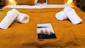 A neatly made bed with a brown textured bedspread, two white towels, and a book titled "Meriann". - Bergstadthaus St. Andreasberg for families & friends, child-friendly & central (Sankt Andreasberg)