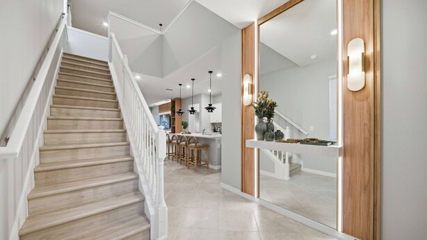 A modern interior with a wooden staircase, a kitchen area, and a dining space. - 7BR house sleeps 18 with private pool (Clermont)