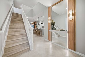 Een modern interieur met een houten trap, een keuken en een eethoek.