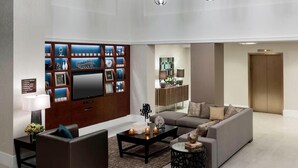 Una sala moderna con una televisión de pantalla plana, un sofá, una mesa de centro y un mueble decorativo de pared.