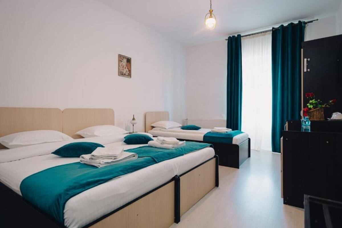 Una habitación de hotel con dos camas, un escritorio y un armario.