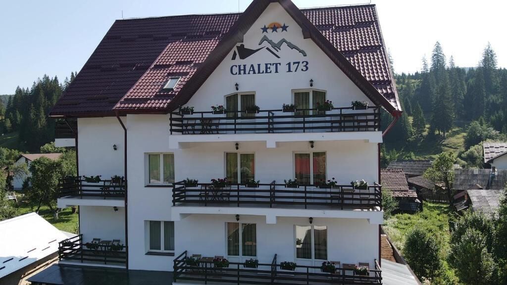 A two-story building with balconies, labeled "CHALET 173".