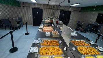 A buffet with various food options, a seating area with tables and chairs, and a modern interior design.