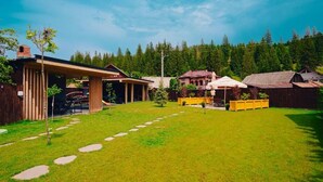 A residential area with a grassy yard, wooden fences, and houses with red roofs.