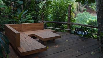 A wooden deck with a built-in bench and a single chair.