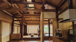 Un intérieur en bois comprenant un canapé, un lit et un coin cuisine.