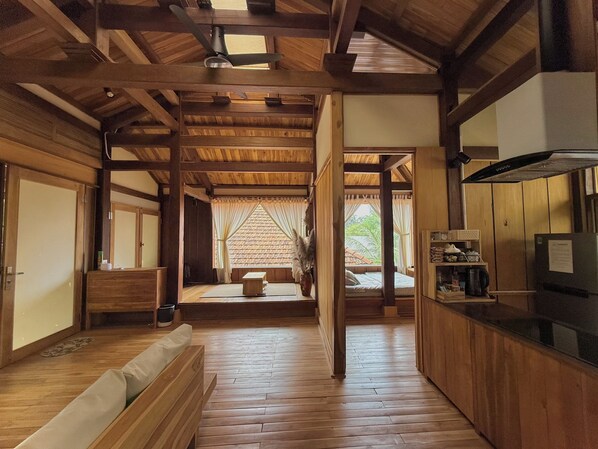 Un intérieur en bois comprenant un canapé, un lit et un coin cuisine.