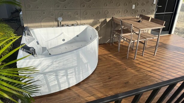 Un espace spa comprenant un bain à remous, des sièges et un mur orné d’un motif texturé.