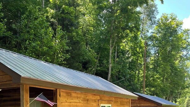Filetta di cabine di legno con tetti in metallo, ognuna con una porta e un piccolo oblò.