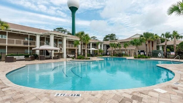 A swimming pool with a sign indicating its depth. - Romantic Island Stay | Free Parking & Breakfast | Pool Access | Pet Friendly (Jekyll Island)