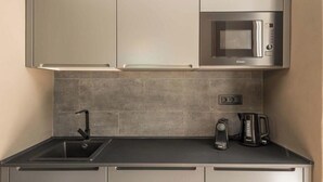 A modern kitchen with a built-in microwave, a coffee maker, and a sink. - Welcome to City Jungle, the guesthouse that transforms your stay into an exotic adventure!Located in the heart of the city, City Jungle offers a unique experience with three rooms, each designed to make you feel immersed in wild nature.At the entrance yo (La Spezia)