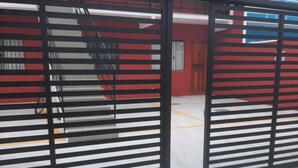 A gated entrance with a metal gate and a concrete floor. - Charming 1-bedroom apartment in Armação dos Búzios perfect for relaxing (Armação dos Búzios)