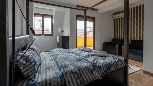 A bedroom with a bed, a desk, and a window. - Apart Hotel Solaris: Deluxe Apartment 4: 30 m2 (Skopje)