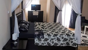 A bedroom with a bed, a TV, a wardrobe, and a desk. - Apart Hotel Solaris: Deluxe Apartment 4: 30 m2 (Skopje)