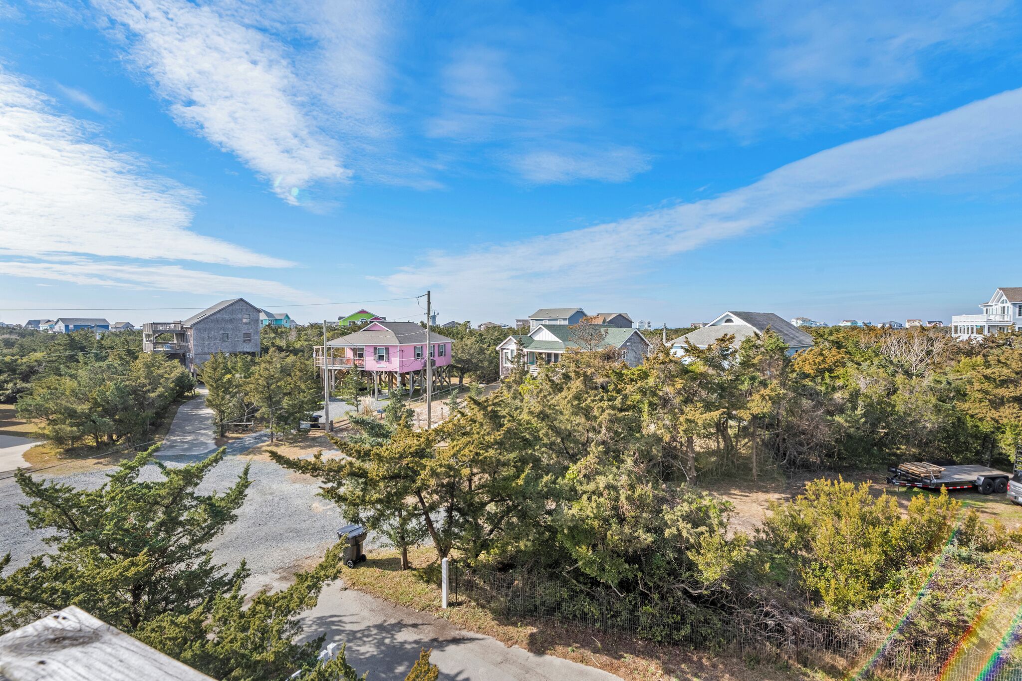 A residential area with houses, a road, and trees.