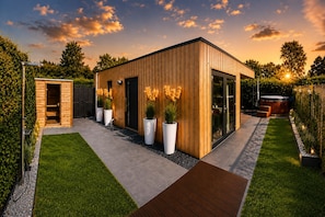 A modern wooden building with a glass door, surrounded by a well-maintained garden and a wooden deck. - Steam & Dream 💥 Surprisedeal 💥 (Heinkenszand)
