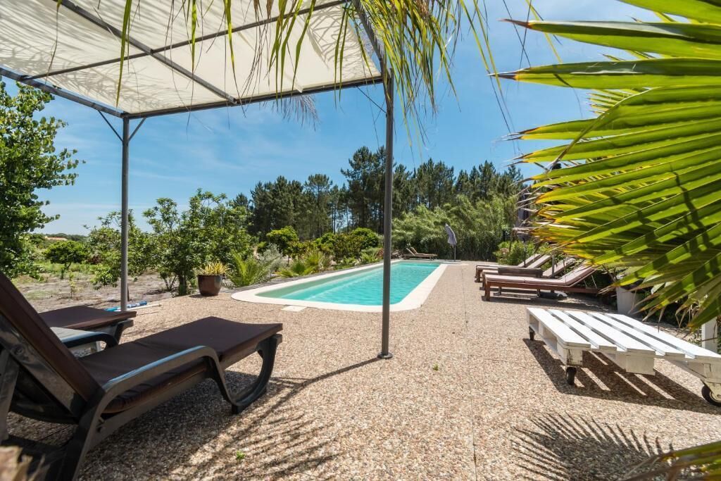 En säsongsöppen utomhuspool, parasoller och solstolar