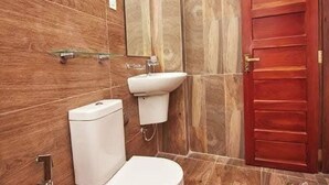 A bathroom with a toilet, sink, and wooden walls. - Pensive Villa - Nuwara Eliya (Nuwara Eliya)
