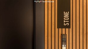 Een houten paneel met een metalen keypad en de tekst 'STONE'.