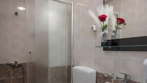 Een badkamer met toilet, wastafel en douche.
