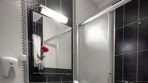 Een moderne badkamer met toilet, wastafel en douche.