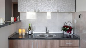 Een moderne keuken met een marmeren spatwand, houten kastjes en een zwart aanrecht.