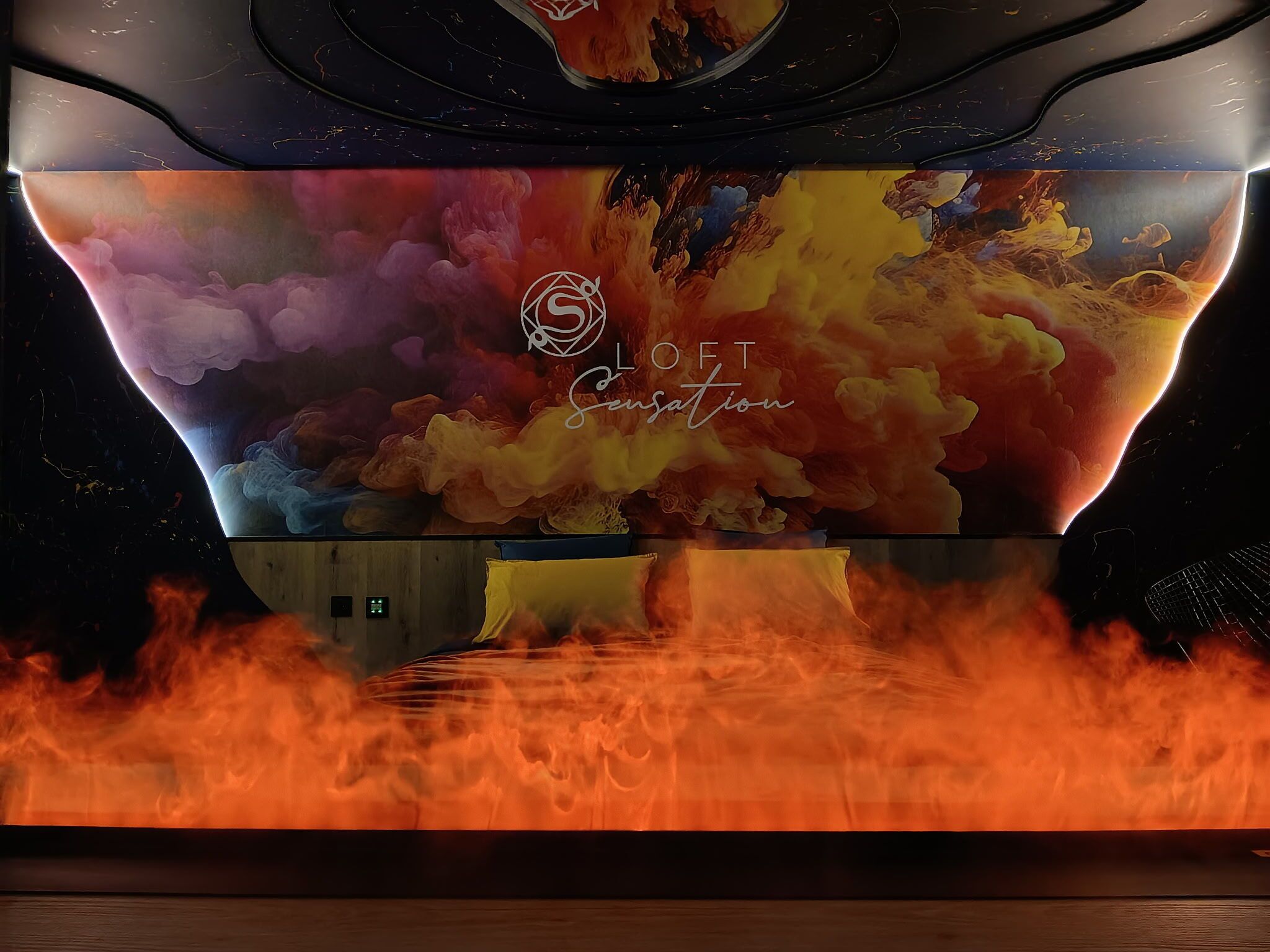 A room with a large digital screen displaying a colorful abstract design.