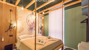 Een gezellige kamer met een bed, een houten wand en een groot raam.