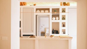 A kitchen with white cabinets, a countertop, and various kitchen items. - Villa Ninetta Ostuni (Ostuni)
