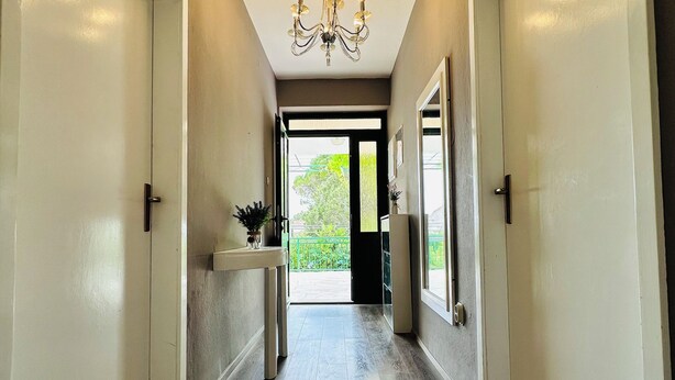 A hallway with wooden flooring, white walls, and a chandelier. - BEACH HOUSE BOL (Bol)