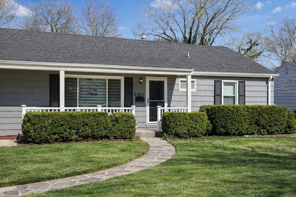 A single-story house with a grey exterior, a front porch, and a stone pathway leading to the entrance. - World Cup 2026 3BR - Centrally located to all KC Action! (Overland Park)
